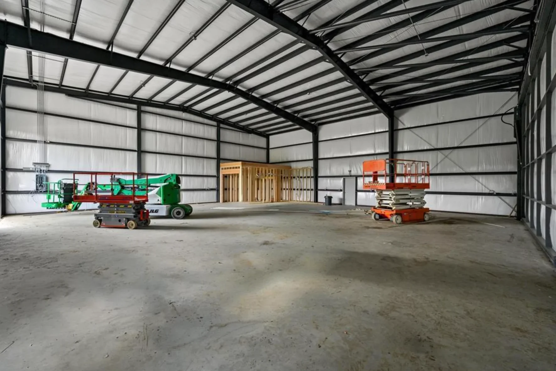 Steel hangar interior during construction with lift equipment